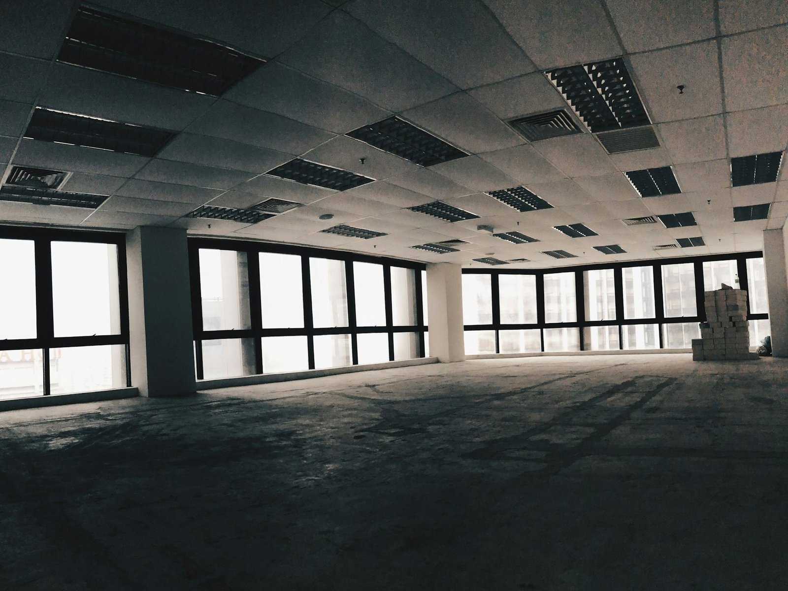 Empty office floor with a tiled ceiling and windows